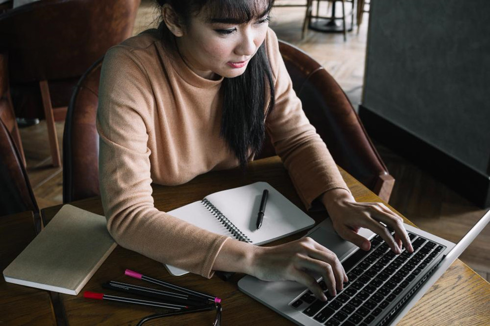 A girl writing on her computer 